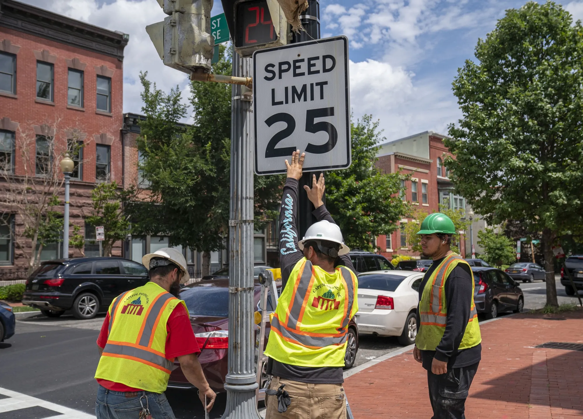 Contractors put up a new speed limit sign in Washington, DC, in 2022. Several US cities have dropped speed limits in recent years in an effort to reduce pedestrian and cyclist deaths.&nbsp;