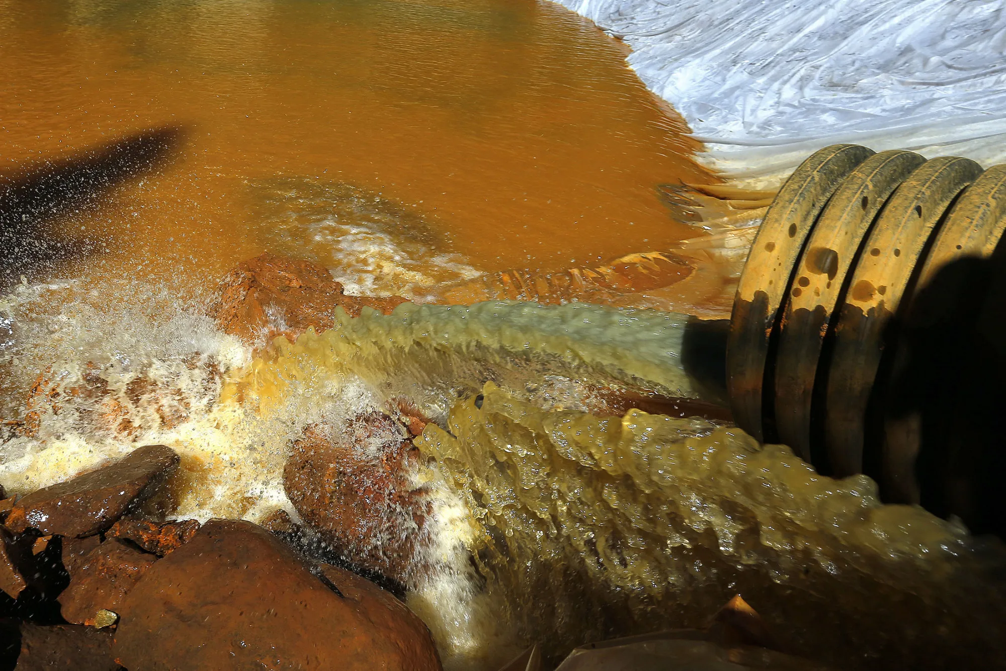 In this Aug. 14, 2015 file photo, water flows through a series of sediment retention ponds built to reduce heavy metal and chemical contaminants from the Gold King Mine wastewater accident, in the spillway about 1/4 mile downstream from the mine, outside Silverton, Colo.
