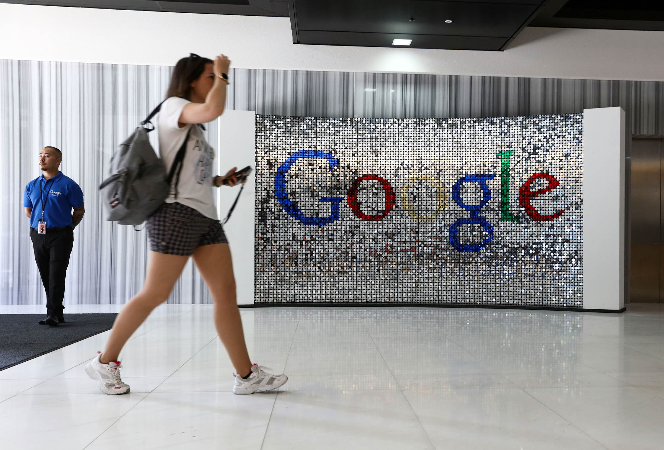 A visitor passes a sign featuring Google Inc.'s logo inside their new U.K. headquarters at Six St Pancras Square in London, U.K., on Tuesday, June 21, 2016. The owner of the world's largest search engine built its new U.K. headquarters on 2.4 acres (1 hectare) of land that's part of a larger development by King's Cross Central LP near the Eurostar rail link to mainland Europe.
