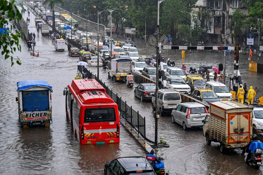 Commuters in traffic along a flooded street after heavy rain showers in Mumbai, on May 26.
