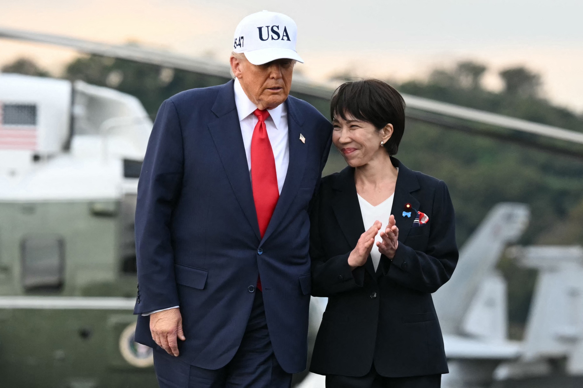 US President Donald Trump (L) and Japan's Prime Minister Sanae Takaichi arrive on board the US Navy's USS George Washington aircraft carrier at the US naval base in Yokosuka on October 28, 2025. (Photo by ANDREW CABALLERO-REYNOLDS / AFP) (Photo by ANDREW CABALLERO-REYNOLDS/AFP via Getty Images) Photographer: ANDREW CABALLERO-REYNOLDS/AFP/Getty Images