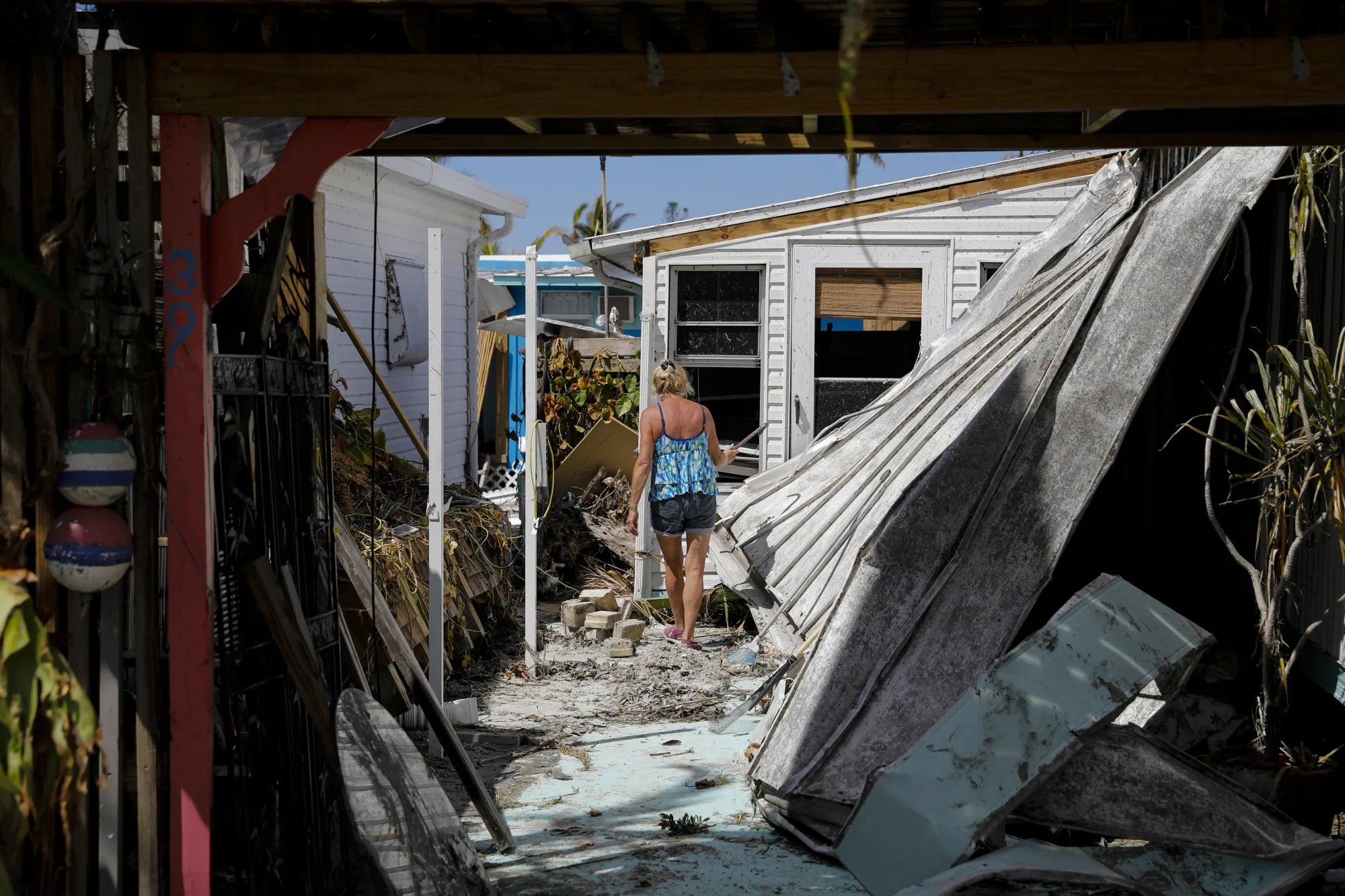 A resident walks inside her damaged house following Hurricane Ian in Matlacha, Florida, US, on Wednesday, Oct. 5, 2022.&nbsp;