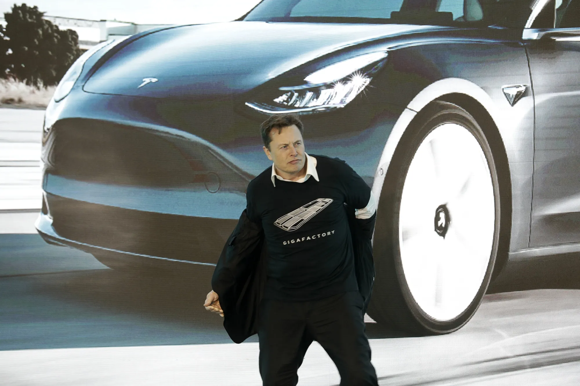 Elon Musk takes off his jacket during the Tesla China-Made Model 3 delivery ceremony in Shanghai in January.
