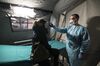 A health worker tests a woman's temperature at Molinette hospital in Turin, Italy on Feb. 26.