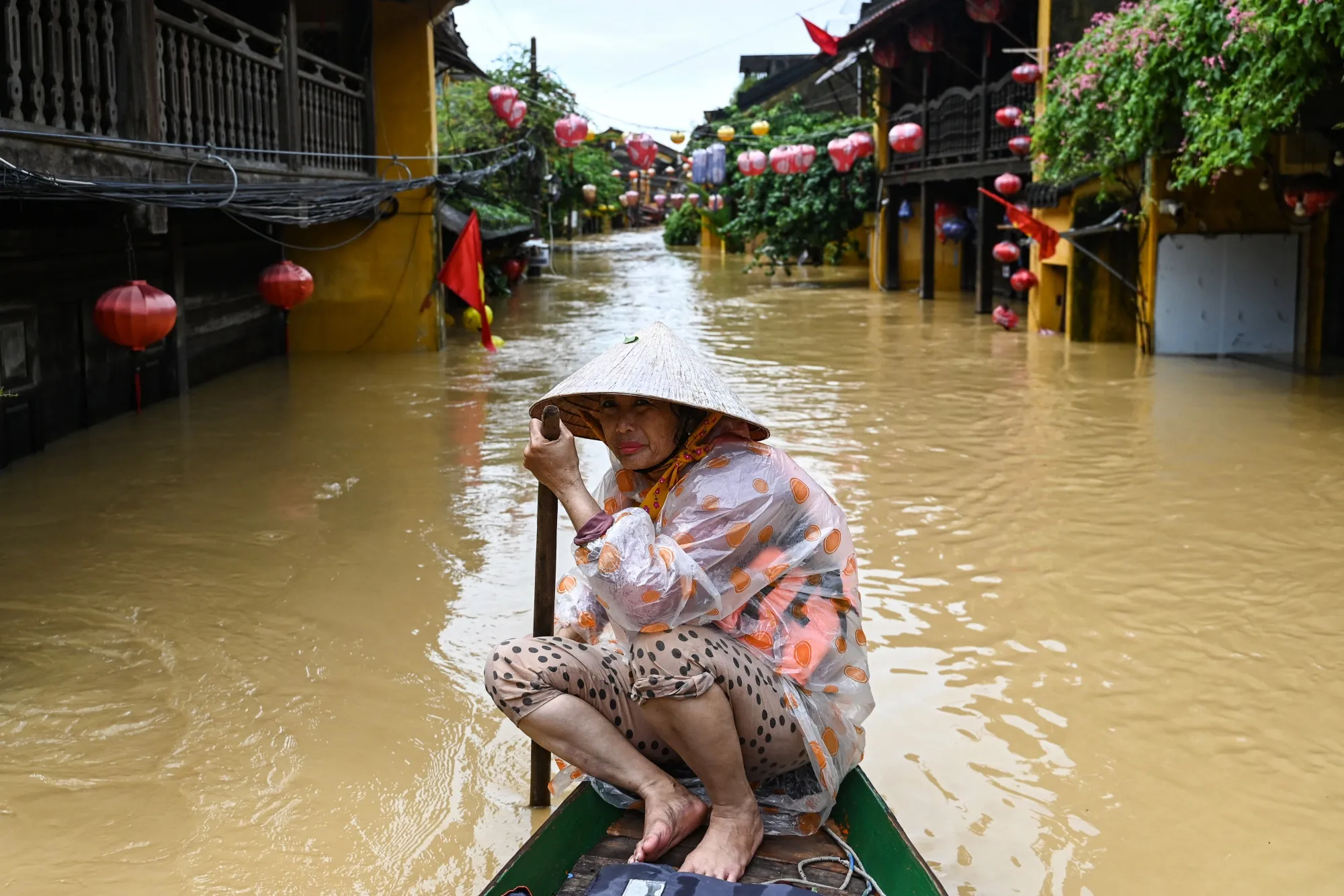 A woman rows a boat on a flooded street following heavy rains in Hoi An on Oct. 30.