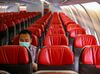 An official sits alone inside an aircraft before leaving Jakarta airport in Tangerang on February 1, 2020, in order to carry Indonesians back home from Wuhan, China.