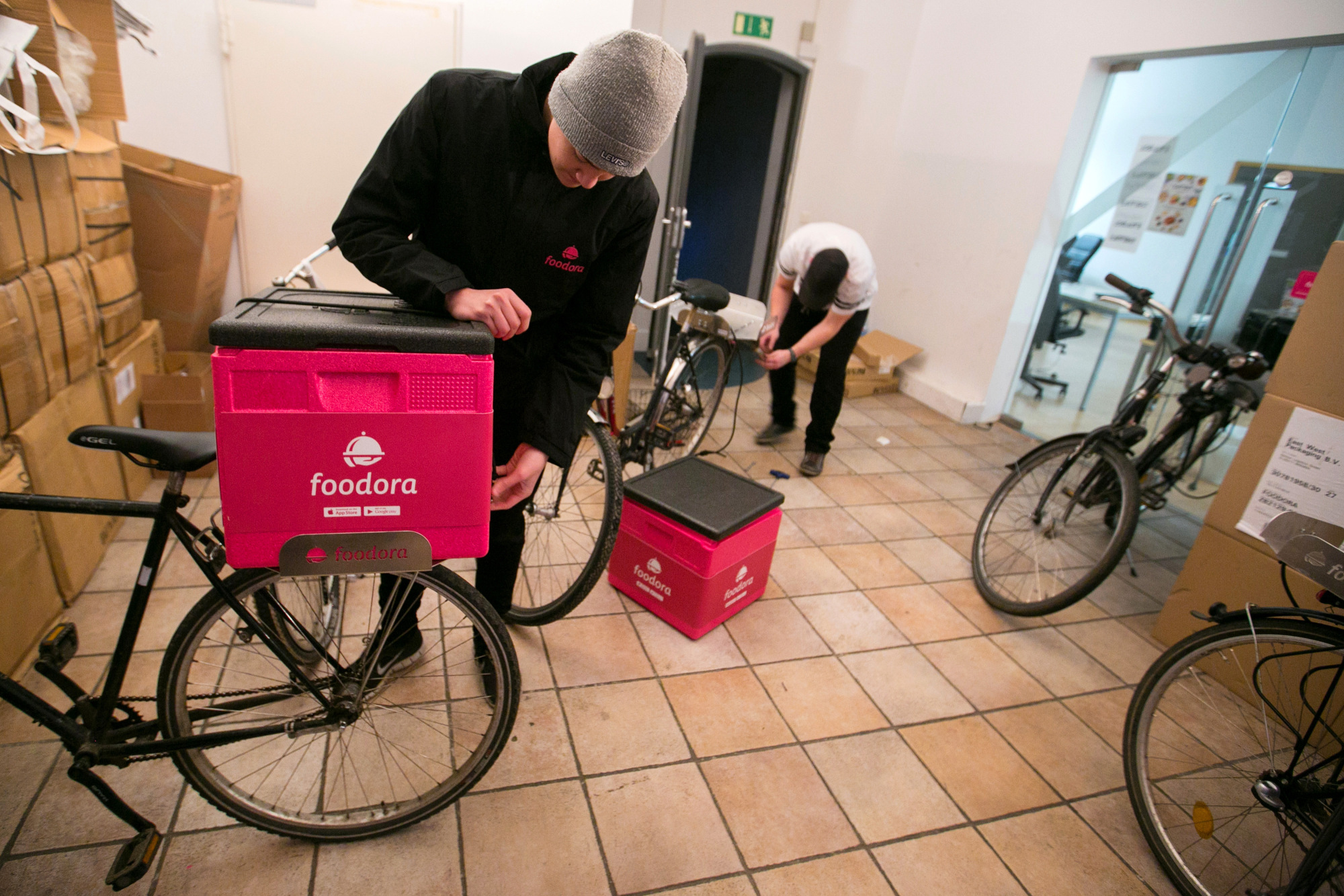 An employee attaches a delivery box to a bicycle inside the headquarters of Foodora&nbsp; in Berlin.