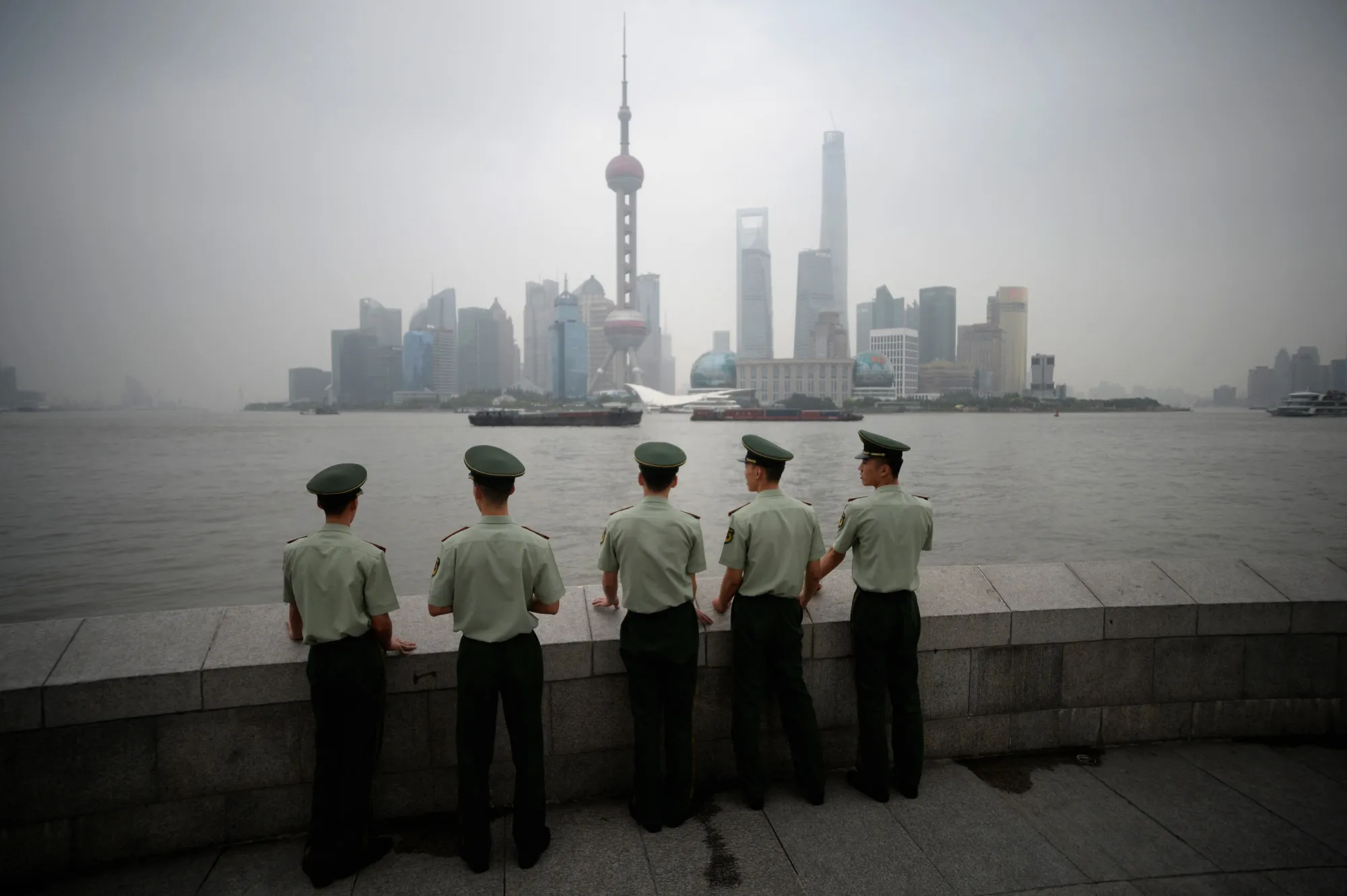 Paramilitary policemen stand in front of the skyline of the Lujiazui Financial District&nbsp;in Shanghai in 2014.
