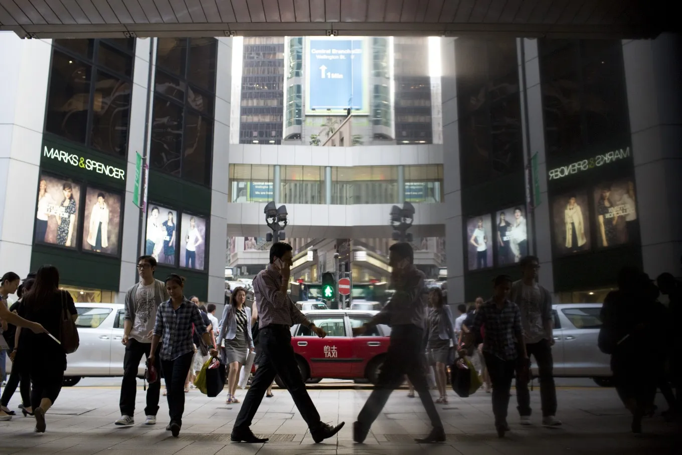 Commuters are reflected in a building in the business district of Central in Hong Kong, China, on Tuesday, Oct. 15, 2013. The Government is scheduled to release unemployment figures on Oct. 17.