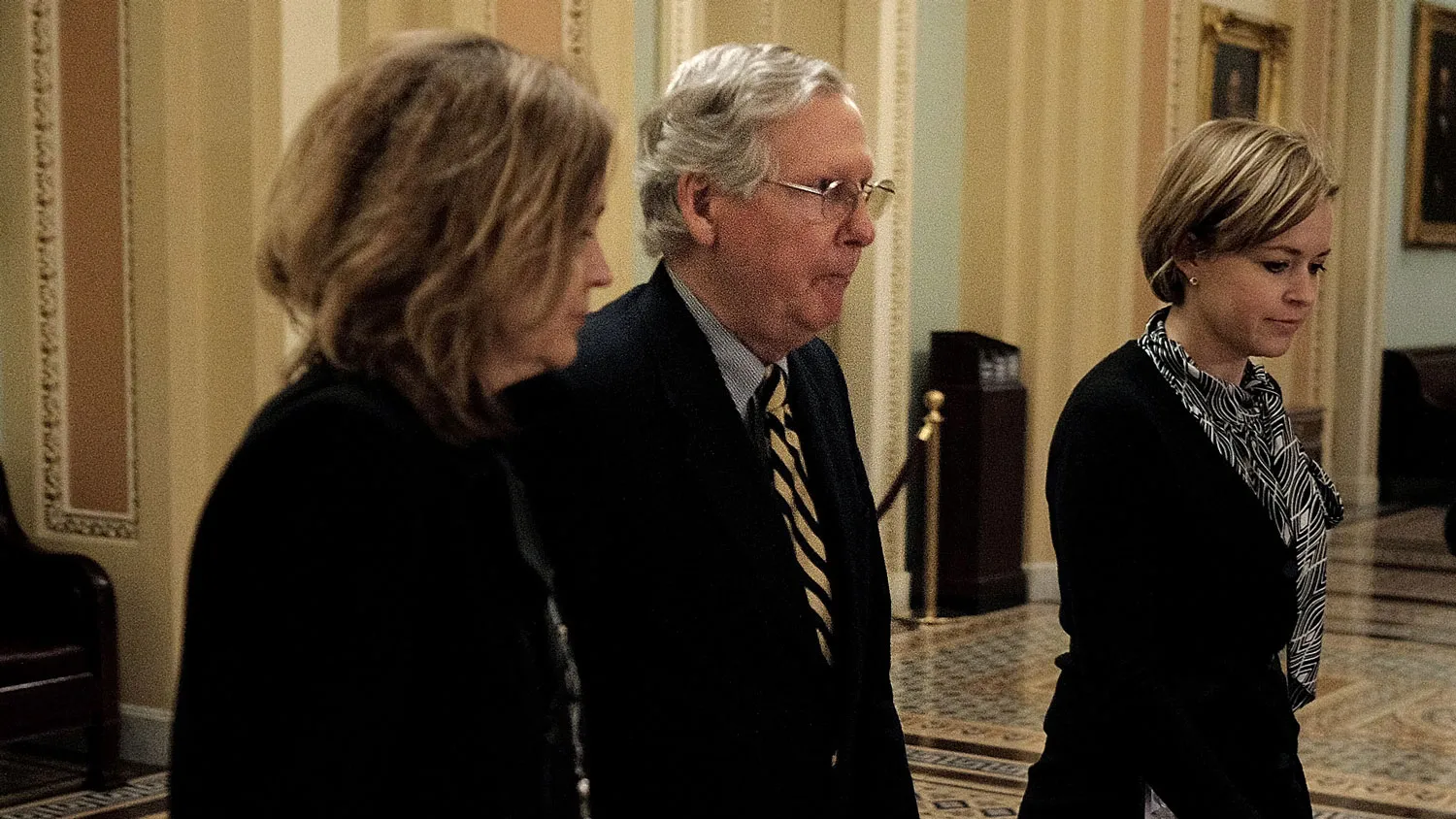 Senate Majority Leader Sen. Mitch McConnell (R-KY), second from left, stays quiet as he leaves the Senate chambers after passing a new stopgap funding bill for the Department of Homeland Security at the U.S. Capitol on February 27, 2015 in Washington, DC.
