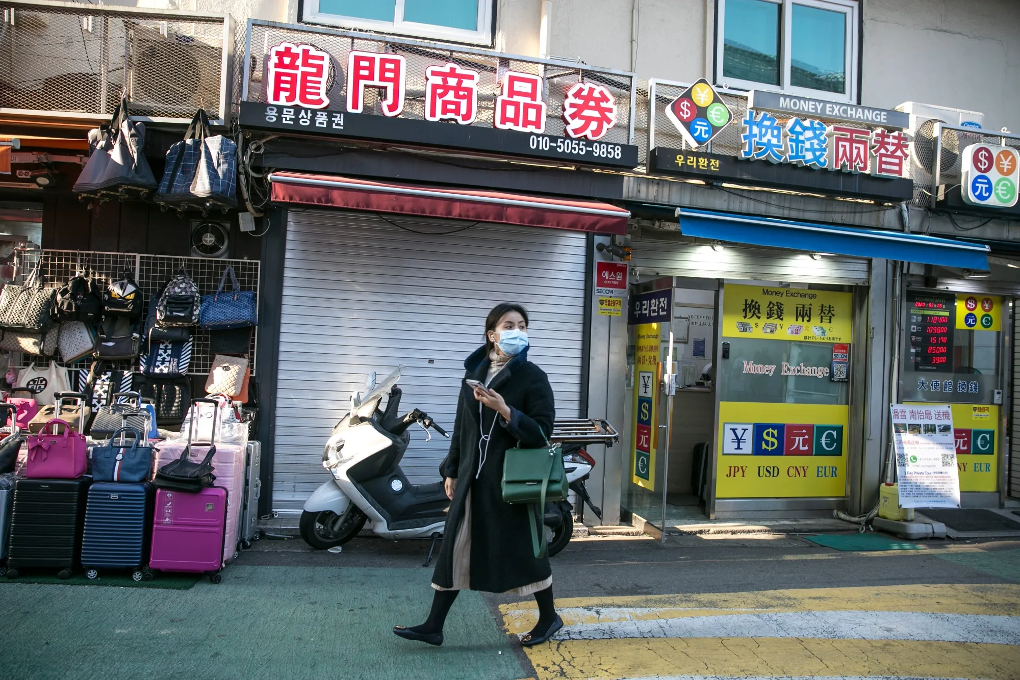 A person wearing a protective mask walks past a shuttered store in the Myeongdong district in Seoul, South Korea, on&nbsp;March 5.&nbsp;