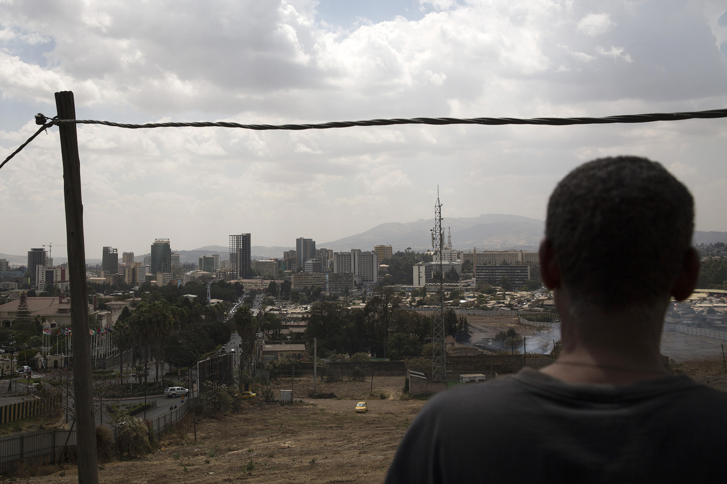 A pedestrian looks out over commercial and residential buildings on the city skyline in Addis Ababa.