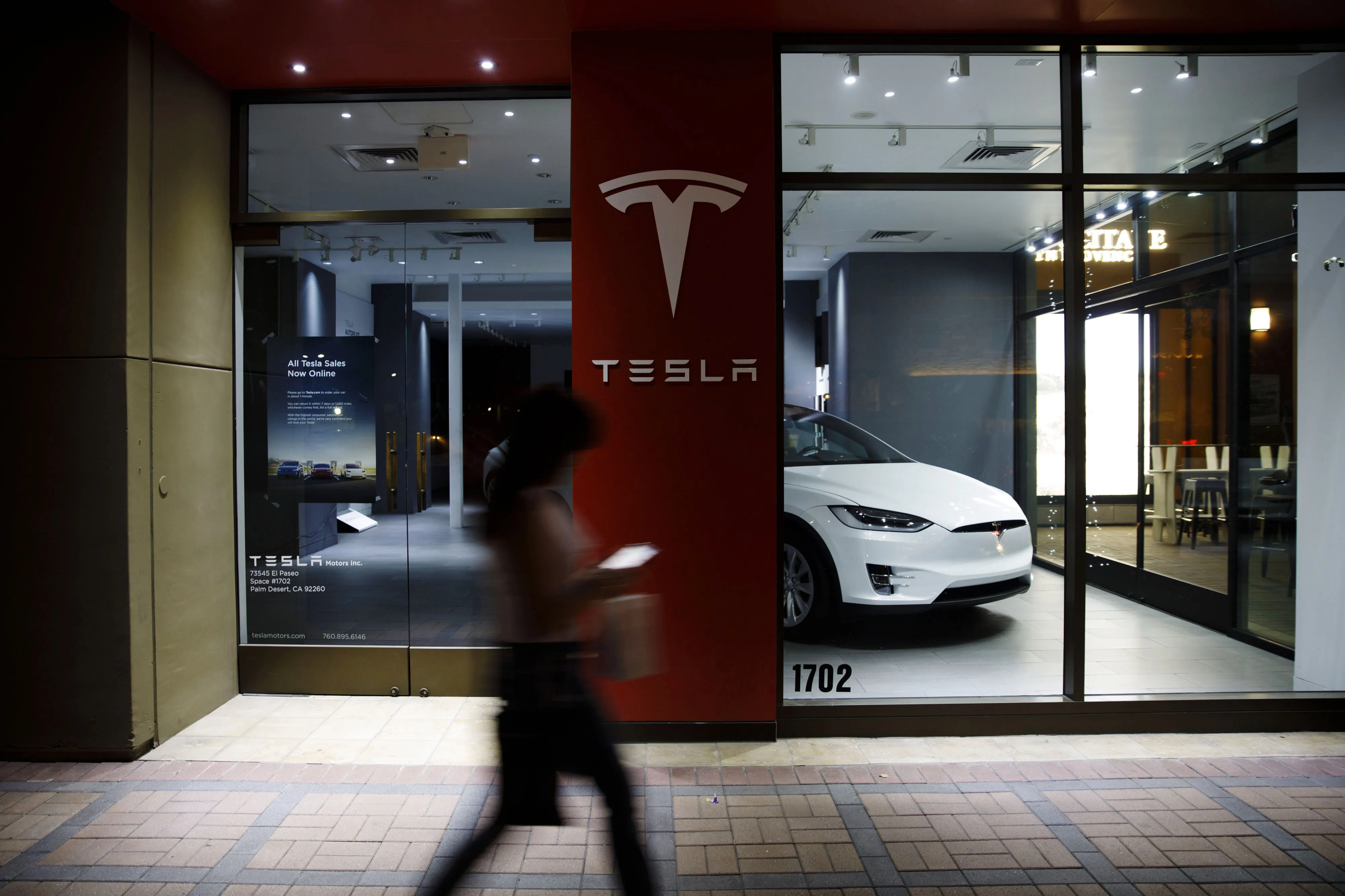 A pedestrian walks past a closed Tesla&nbsp;store in Palm Desert, California.