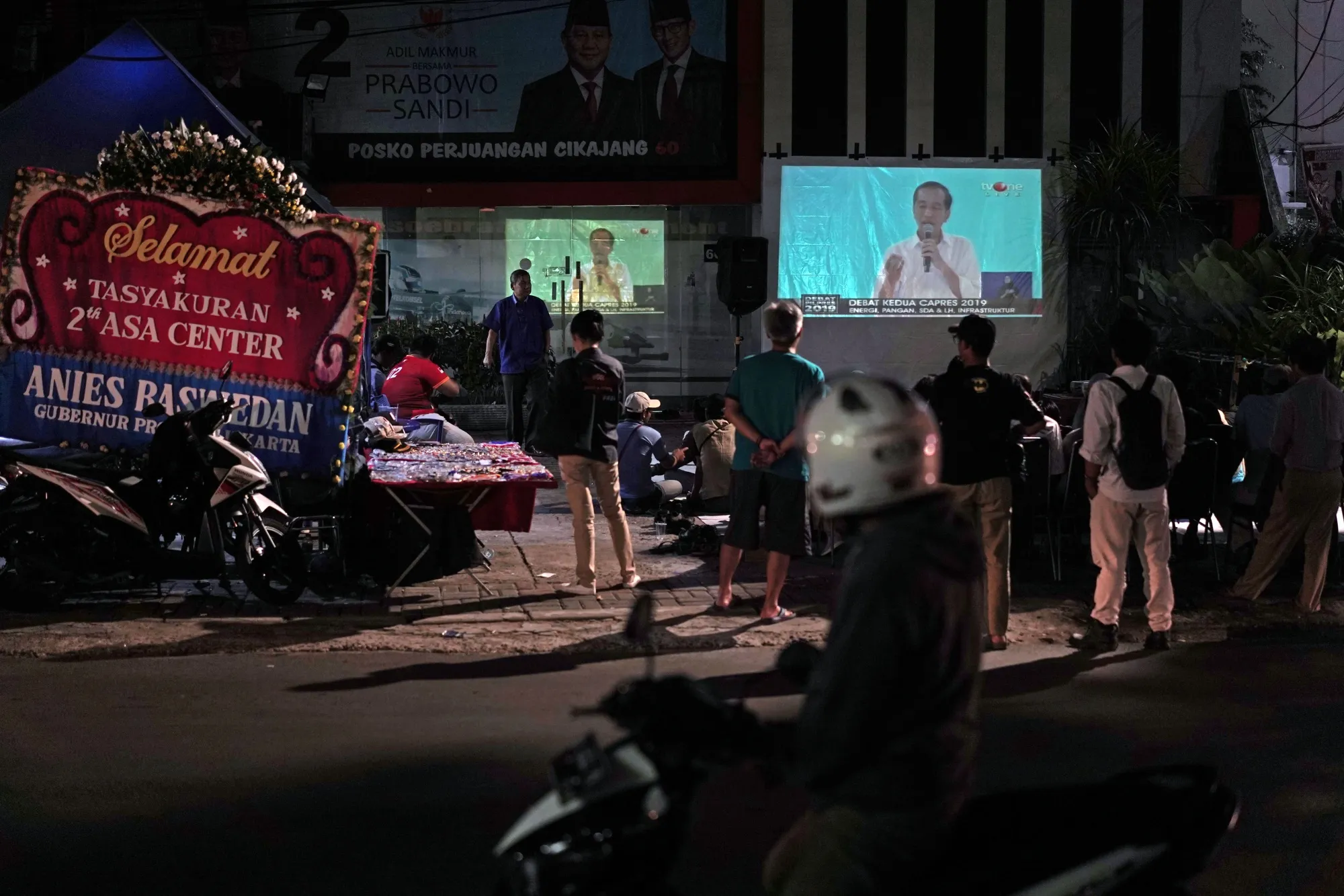 People watch large screens showing the second presidential debate outside in Jakarta, Indonesia, on Feb. 17, 2019.