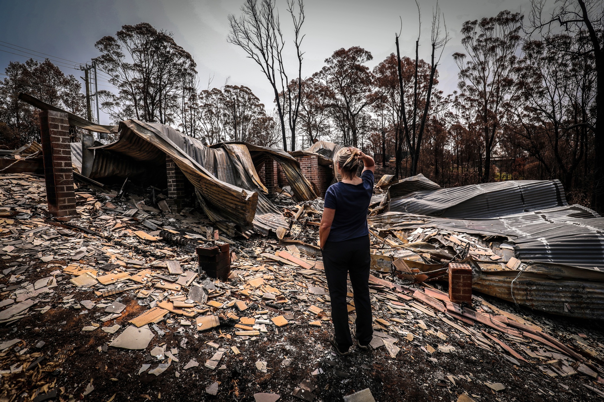A&nbsp;resident looks at the remains of her home that was burned out by wildfires near Lake Conjola, New South Wales on Jan. 15.