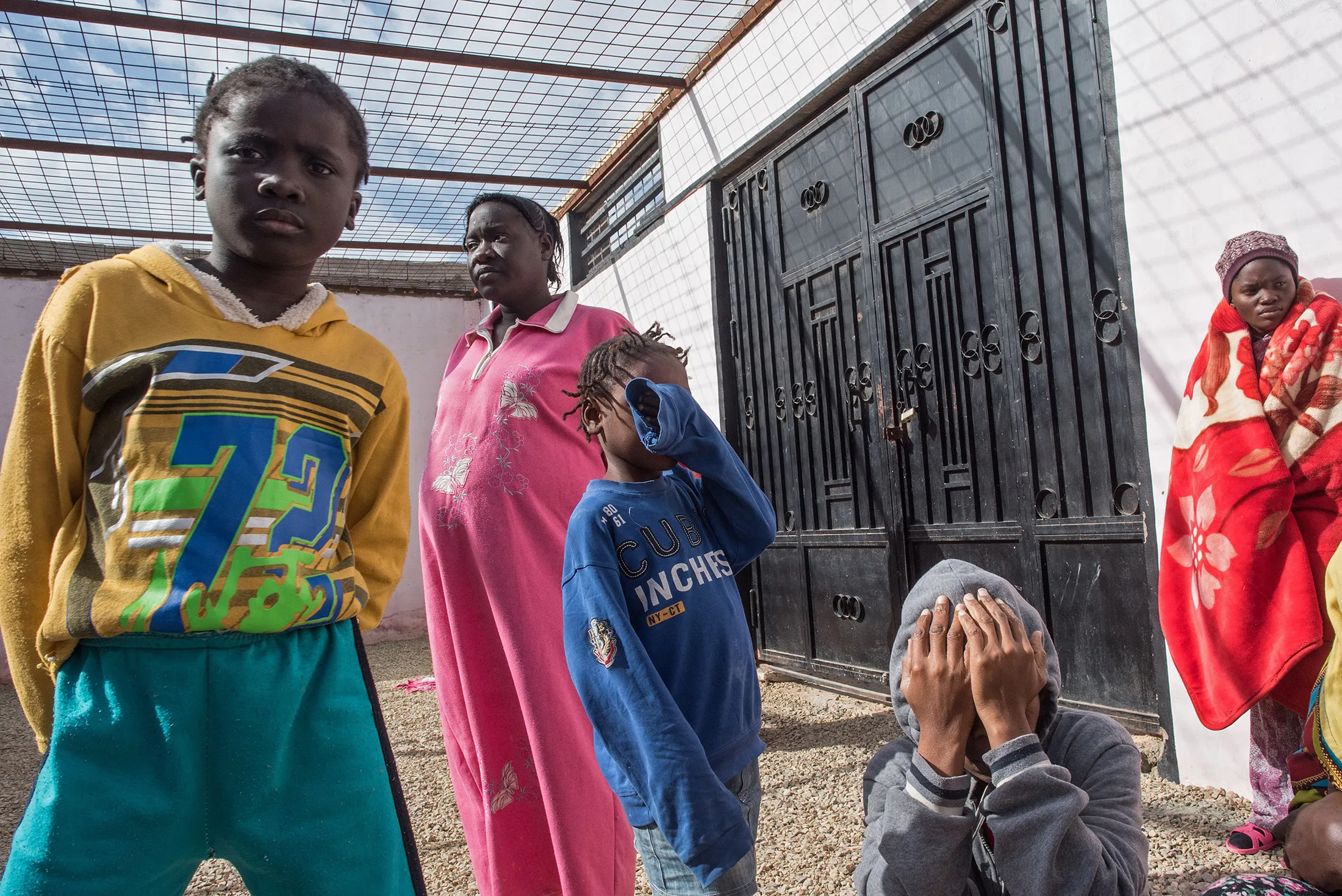 An African migrant woman and children wait at the Tariq Al-Matar detention center on the outskirts of&nbsp;Tripoli on Nov. 27, 2017.