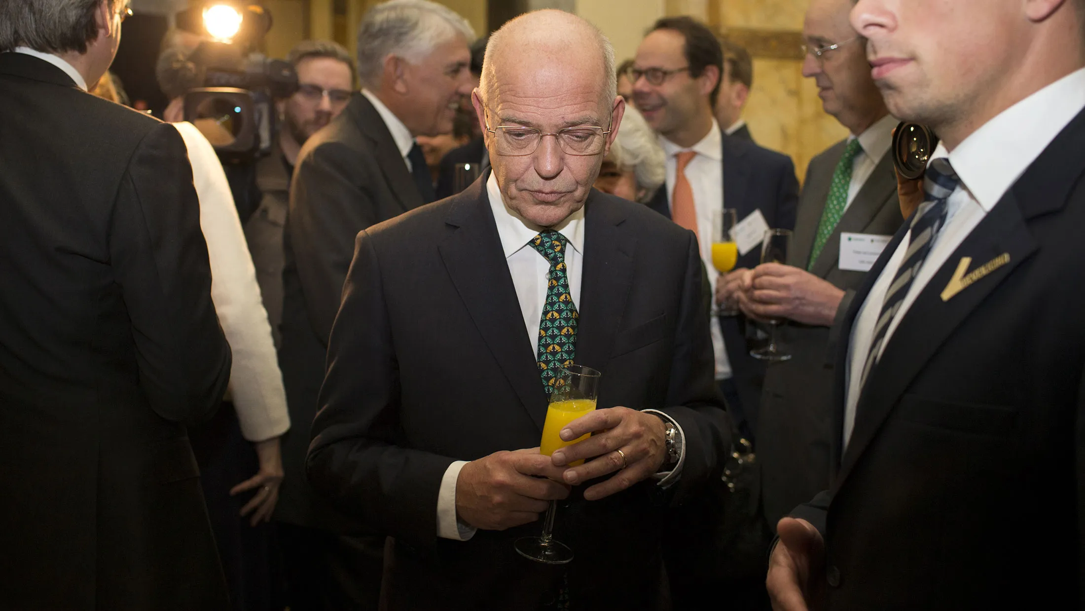 Gerrit Zalm, chairman of ABN Amro Group NV, holds a glass of orange juice after opening trading at Amsterdam Stock Exchange on Nov. 20, 2015.
