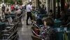A waiter serves customers on the outdoor terrace of a traditional pastry shop, also known as a pastelaria suica, in Rossio square in Lisbon, Portugal.