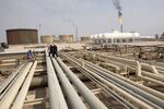 Iraqi workers walk on pipelines of an oil refinery near the city of Basra in 2009. In November of that year, Iraq awarded the right to develop the West Qurna-1 field to a consortium led by Exxon and Shell.