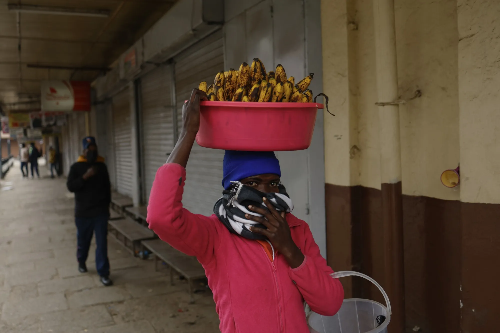 A street vendor protect his mouth from lingering tear gas.
