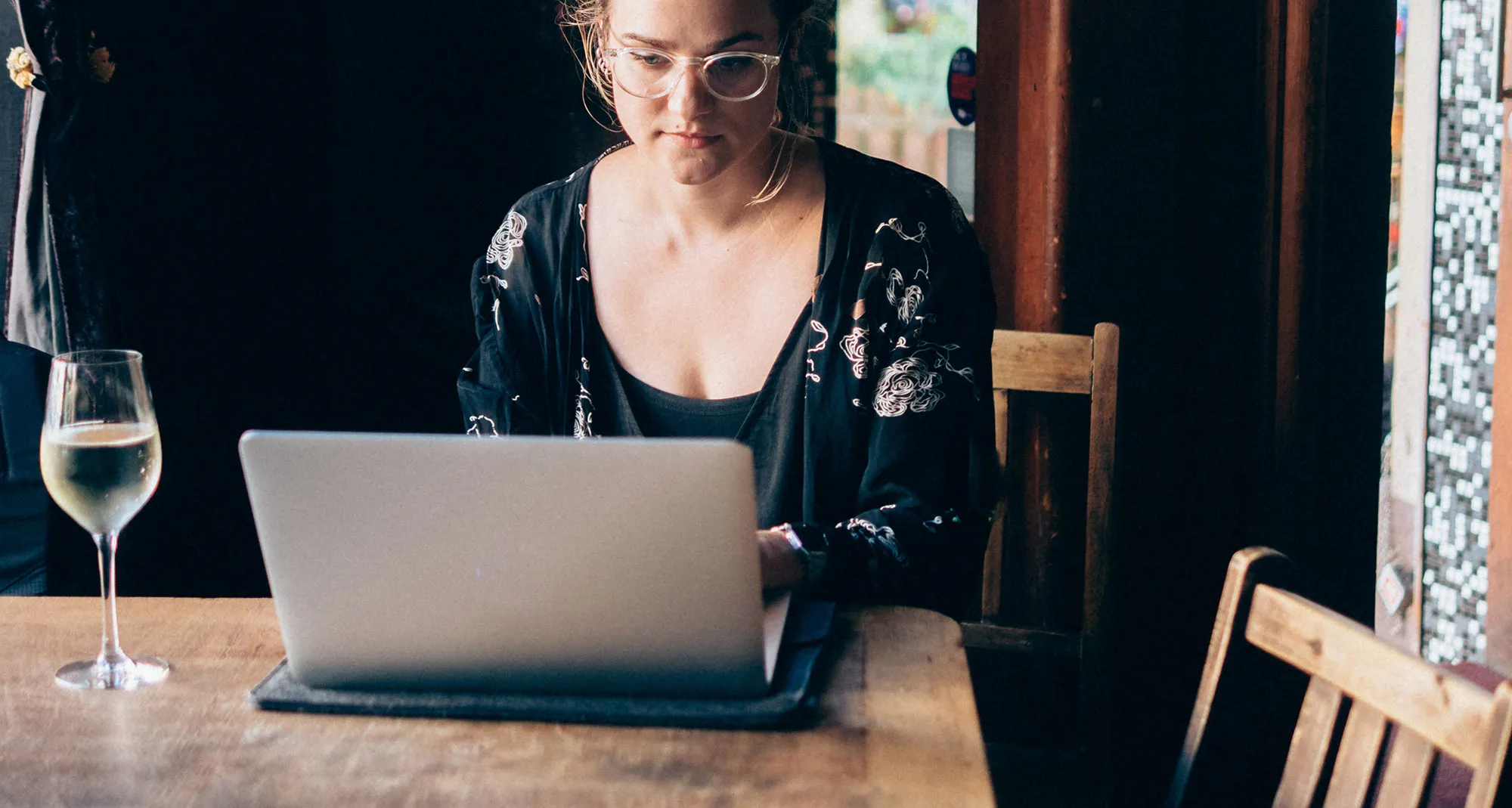 Young Woman Using Laptop In Bar