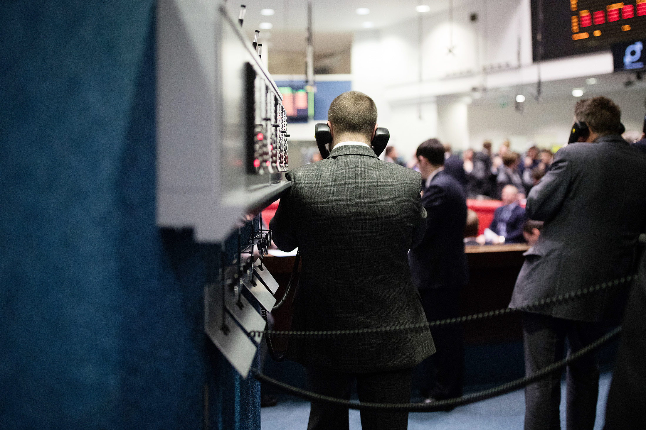 A trader uses telephones as he works from the trading floor of the open outcry pit at the London Metal Exchange (LME) in London.
