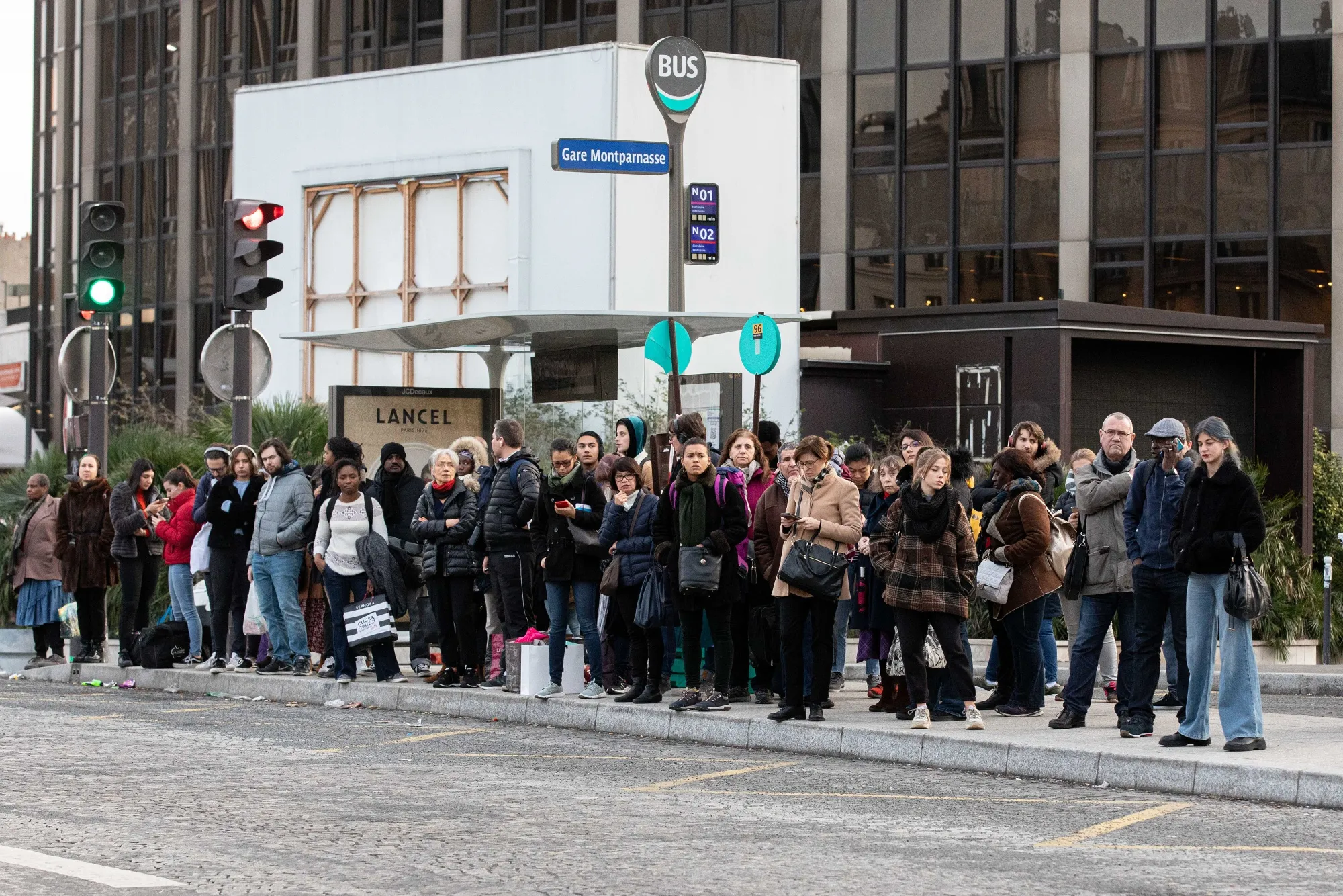 Commuters at a bus stop in Paris.