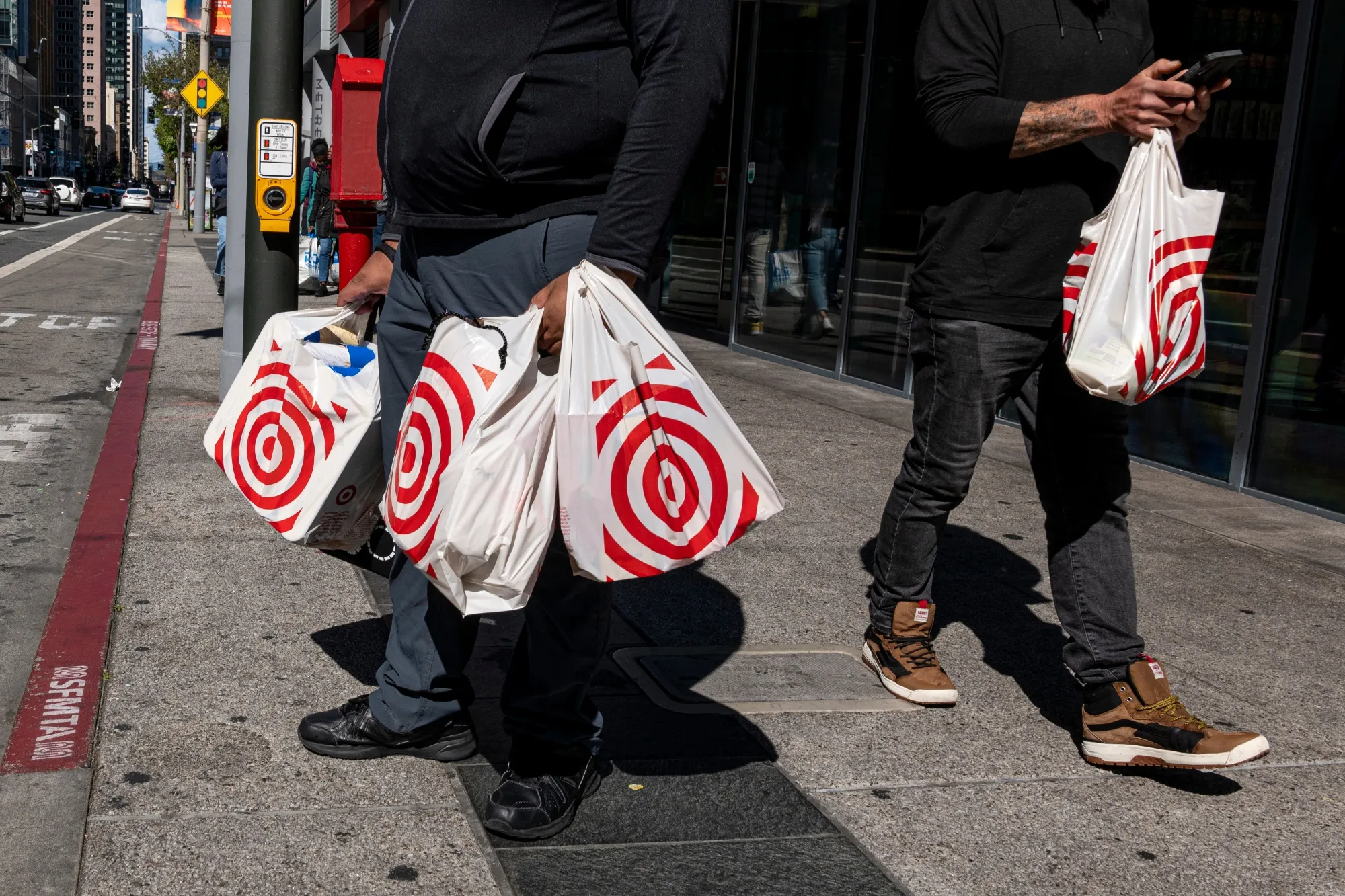 Shoppers carry Target shopping bags in front of a store in San Francisco.