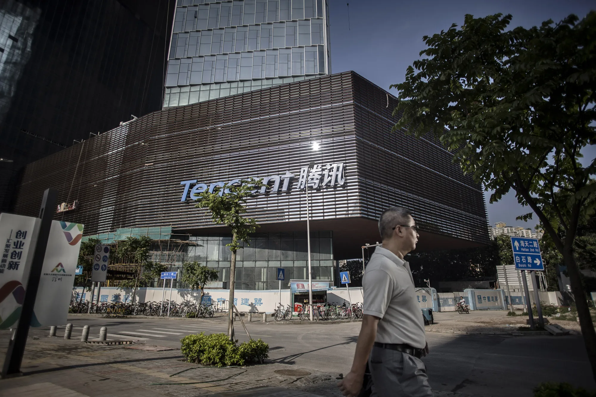 A pedestrian walks past Tencent Holdings Ltd.'s new under construction headquarters in Shenzhen, China,.