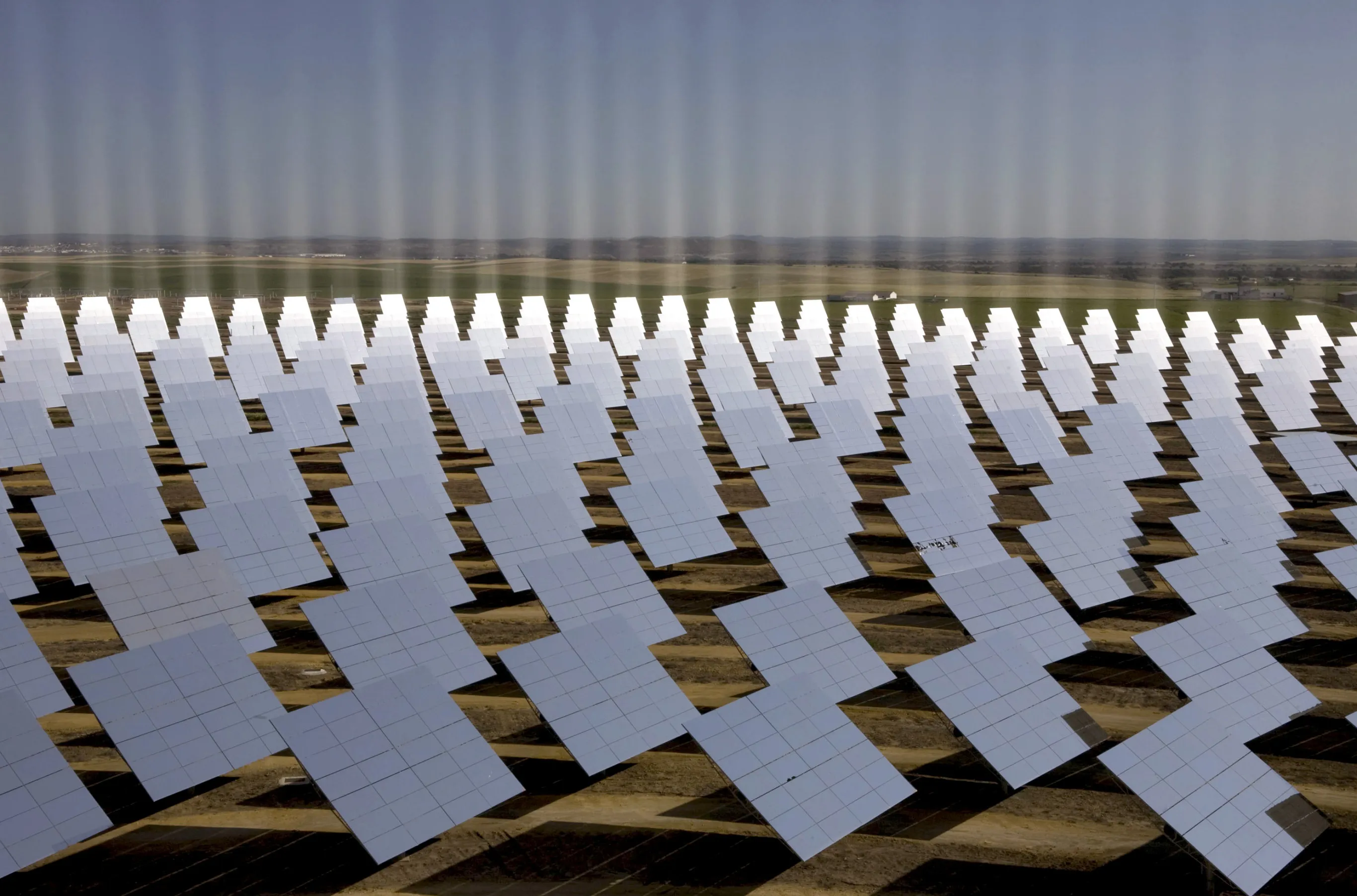 Solar troughs redirect the sun's rays to a central tower which heats water to generate steam to power turbines, at the Abengoa solar-thermal plant in Spain.
