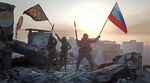 Yevgeny Prigozhin's Wagner Group military company members wave a Russian national and Wagner flag atop a damaged building in Bakhmut, Ukraine.  (Prigozhin Press Service via AP)