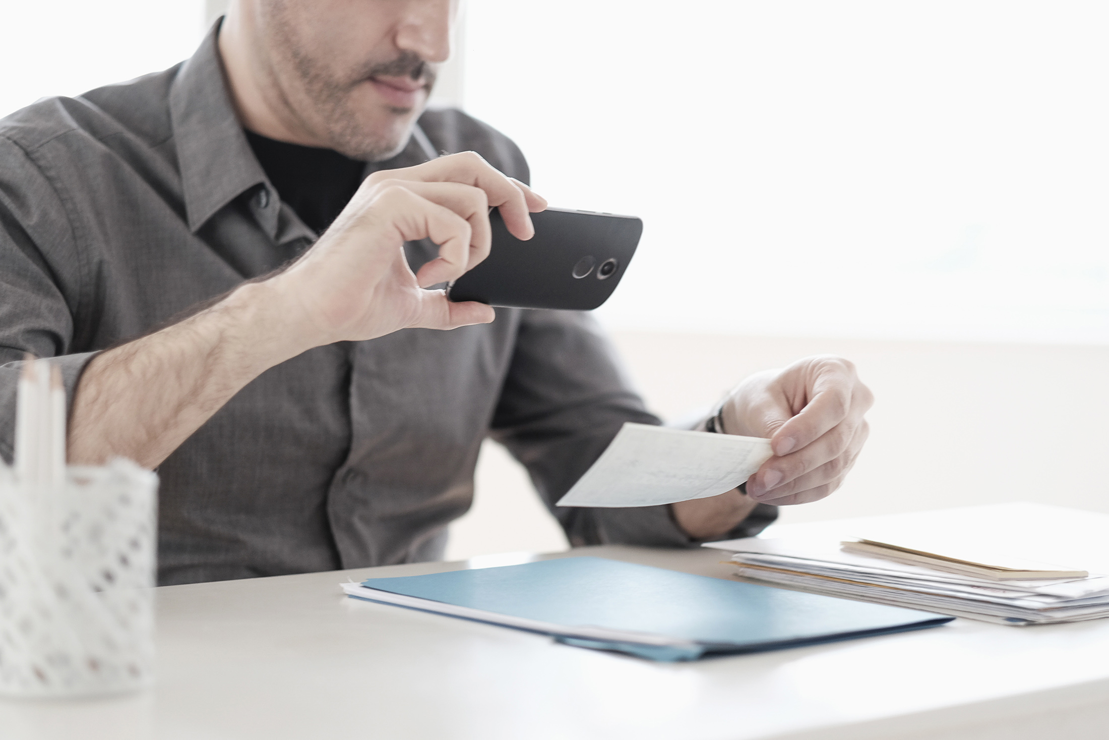 Man photographing check with smart phone