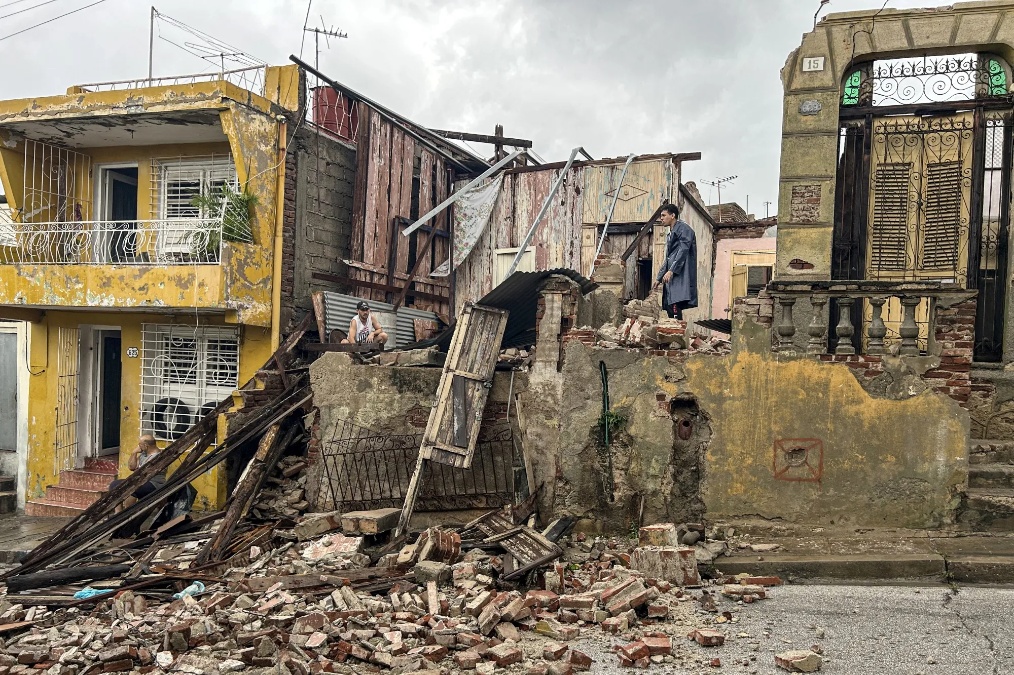 Men salvage belongings from the rubble of her their home after it collapsed during Hurricane Melissa's passage through Santiago de Cuba, Cuba, on Oct. 29.&nbsp;