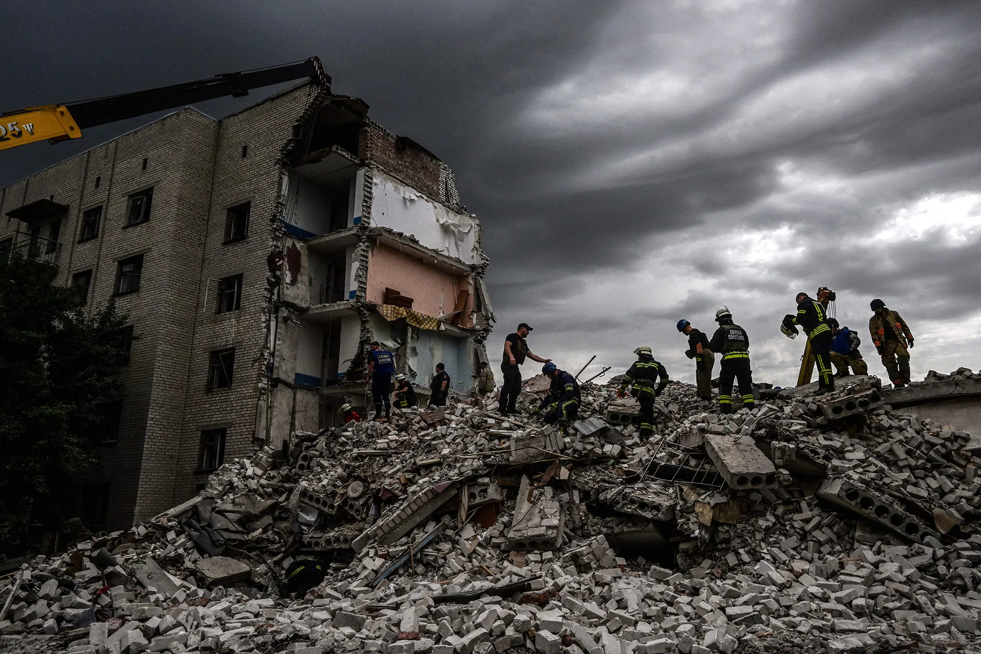 Firefighters and members of a rescue team clear the scene after a building was partially destroyed following shelling, in Chasiv Yar, eastern Ukraine, on July 10.&nbsp;