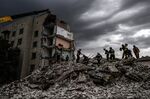 Firefighters and members of a rescue team clear the scene after a building was partially destroyed following shelling, in Chasiv Yar, eastern Ukraine, on July 10. 