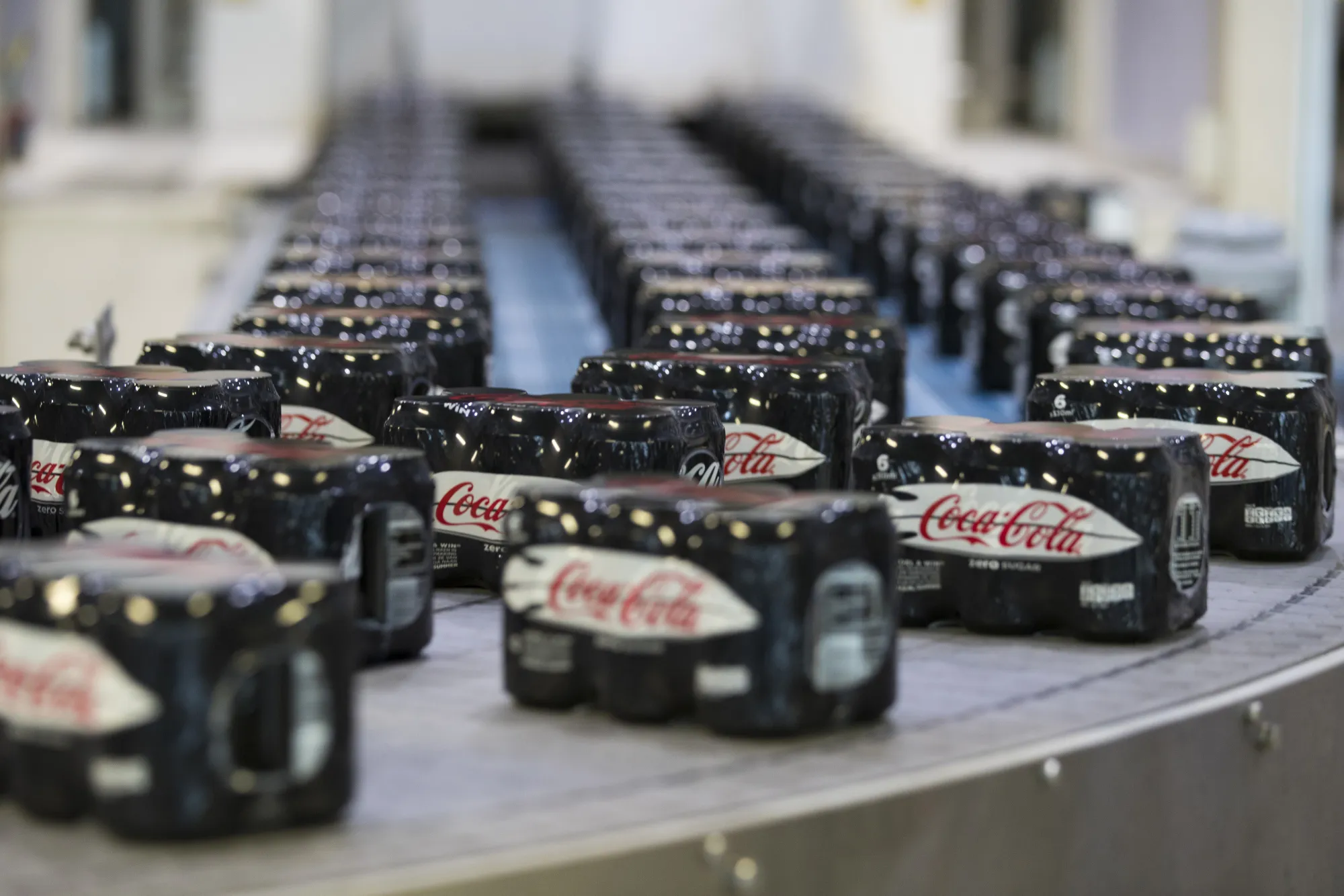 Sealed six packs of Coke Zero sugar free soft drink cans on a conveyor belt at the Coca-Cola Co. factory in Dongen, Netherlands.