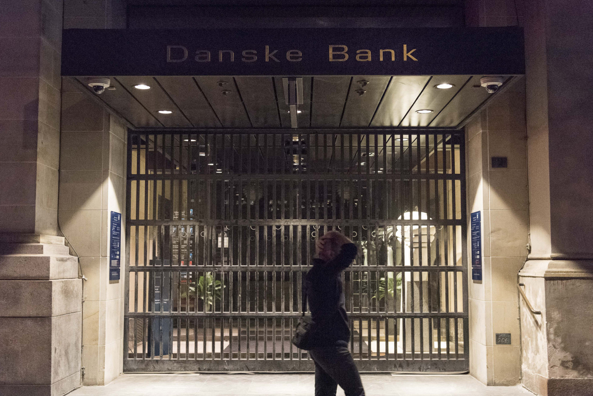 A pedestrian walks past security gates at the headquarters of Danske Bank A/S in Copenhagen.