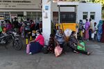 People wait to buy kerosene oil at a gas station in Kandy on June 13.
