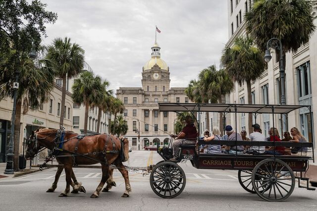 People are seen on a horse-drawn carriage tour in Savannah.
