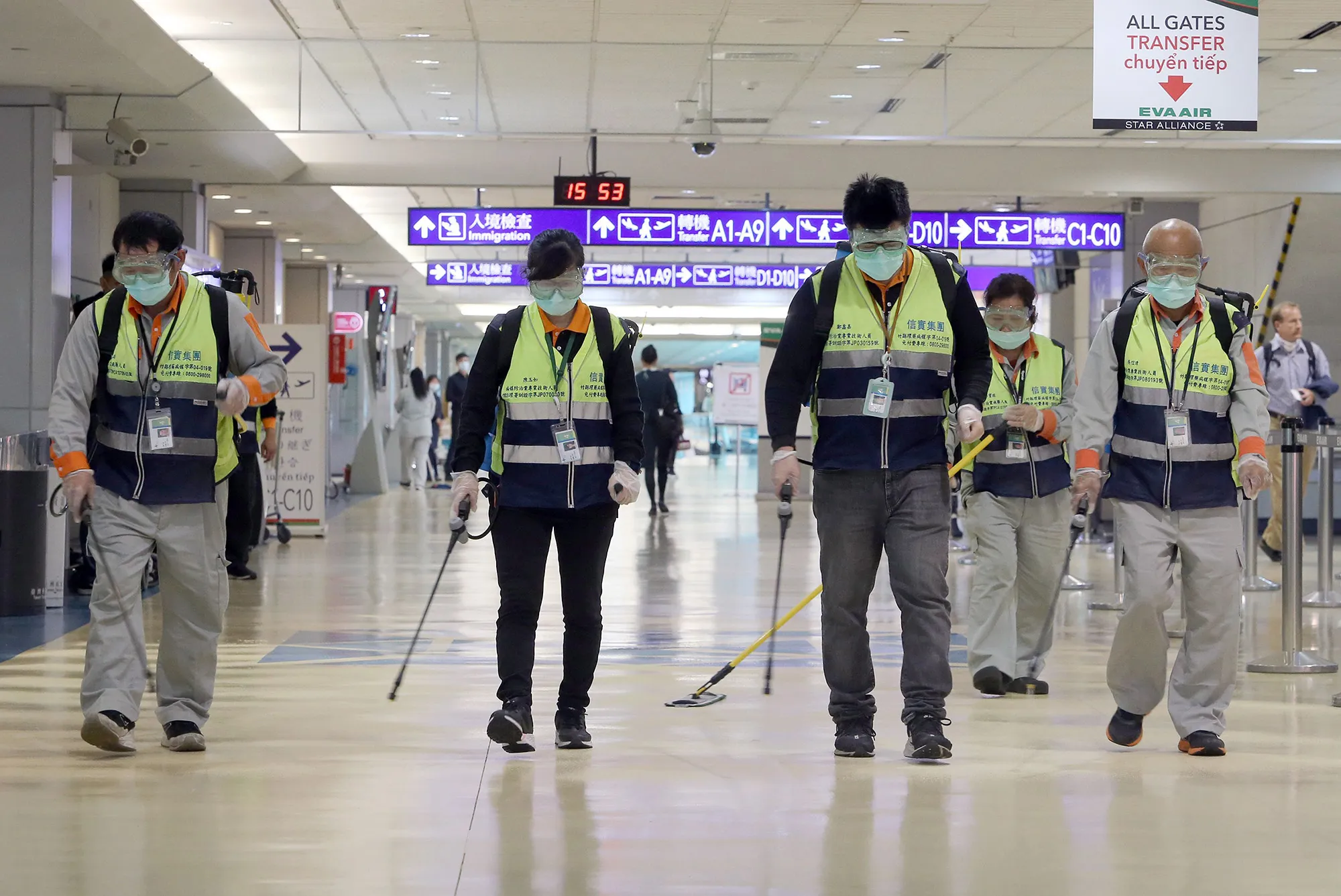 Masked workers disinfect a passenger throughfare at the Taoyuan International Airport in Taiwan on Jan. 22.
