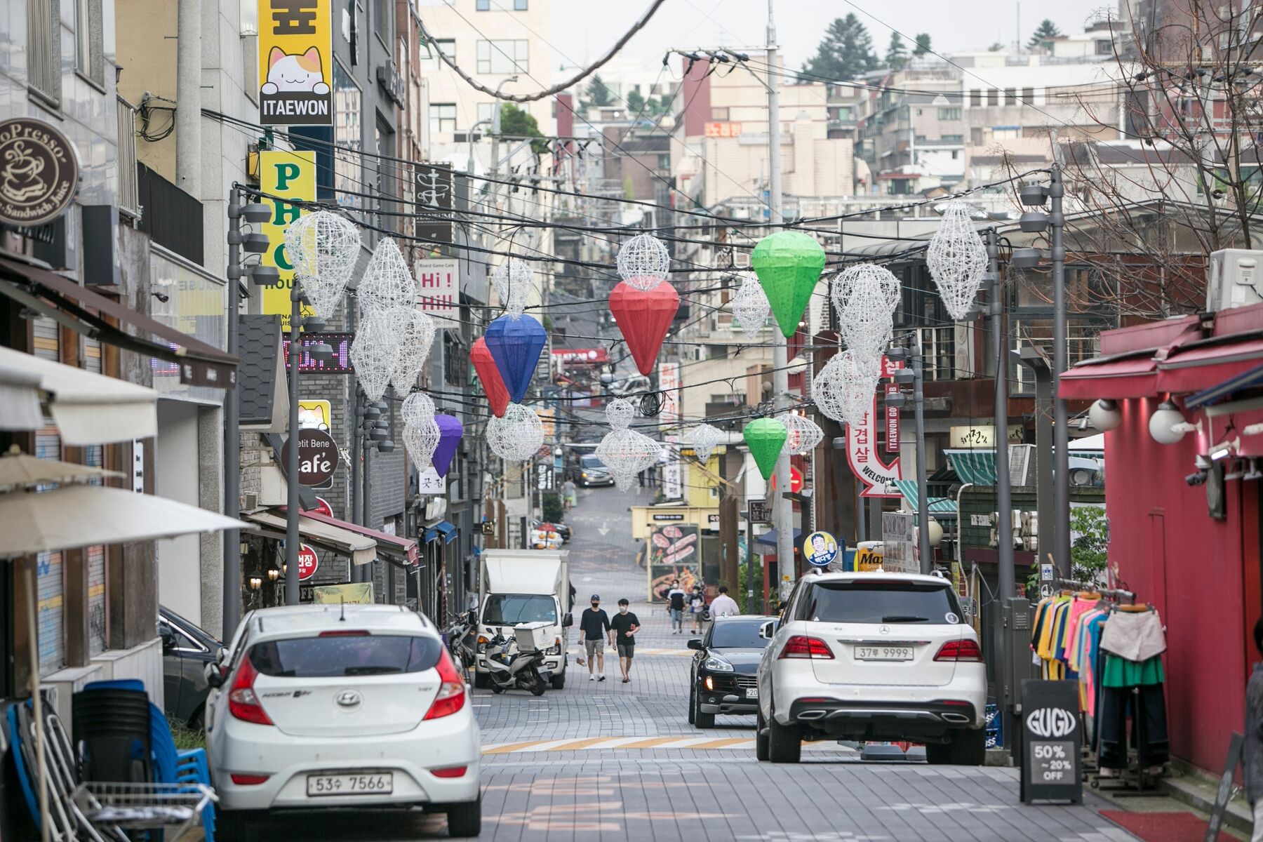 Pedestrians wearing protective face masks walk through an empty street in the Itaewon district of Seoul, South Korea, on Friday, Aug. 21, 2020. 