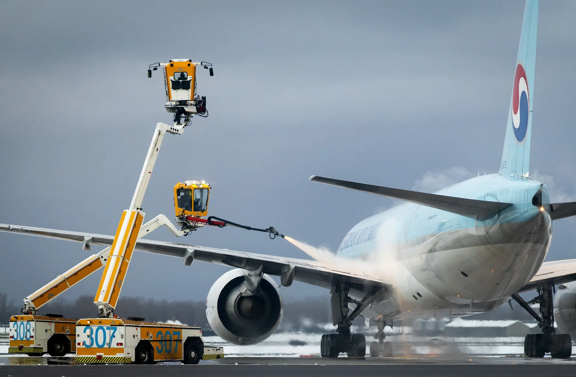 An aircraft is de-iced at Schiphol Airport.