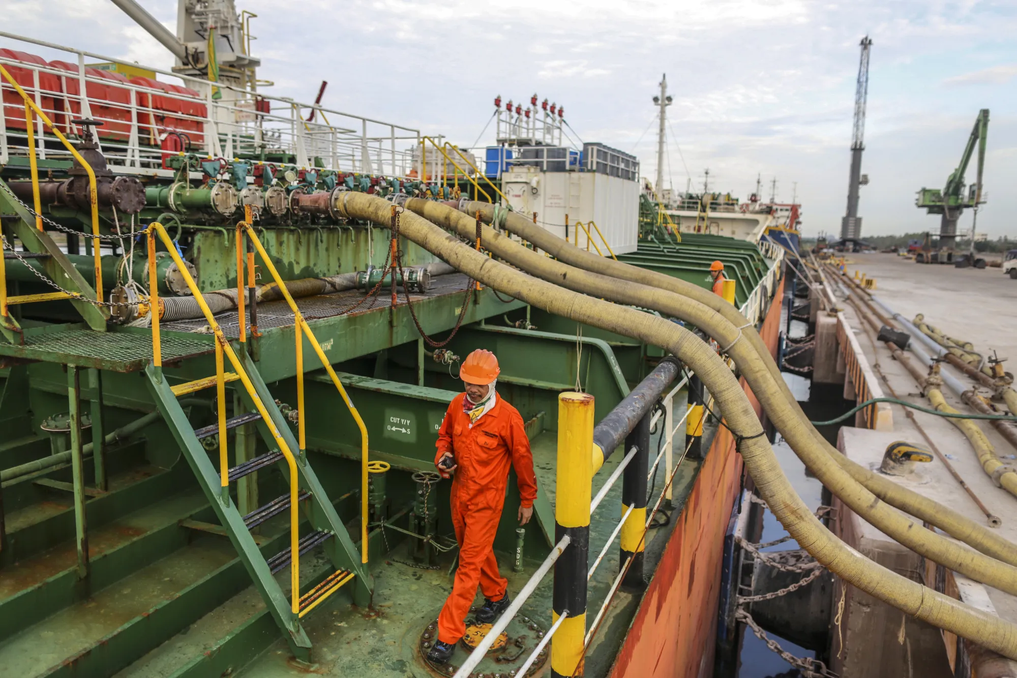 Workers supervise oil being moved on a&nbsp;tanker&nbsp;at Krishnapatnam Port in Krishnapatnam,&nbsp;India.