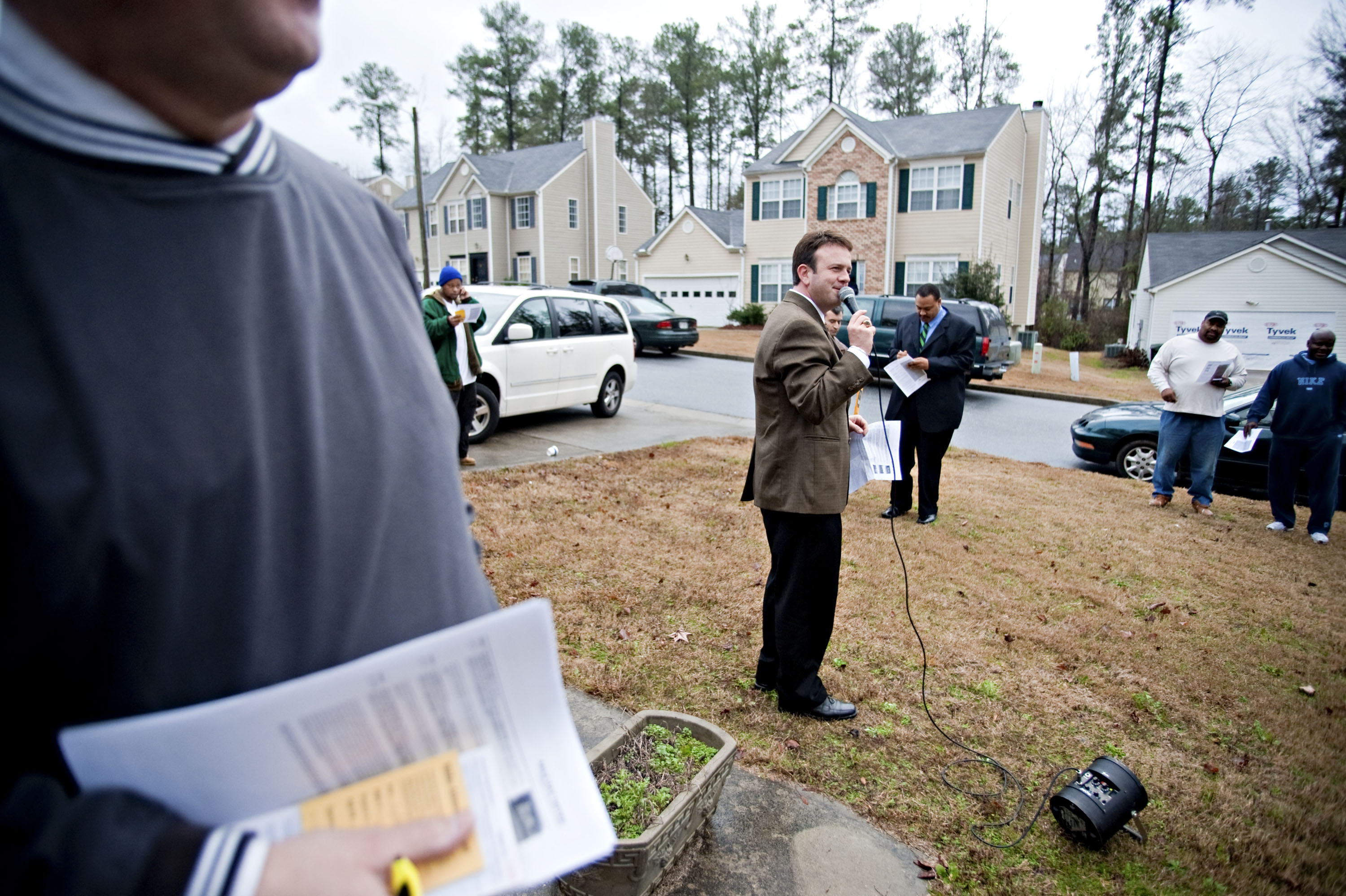 An auctioneer speaks to potential bidders outside a home in Atlanta.
