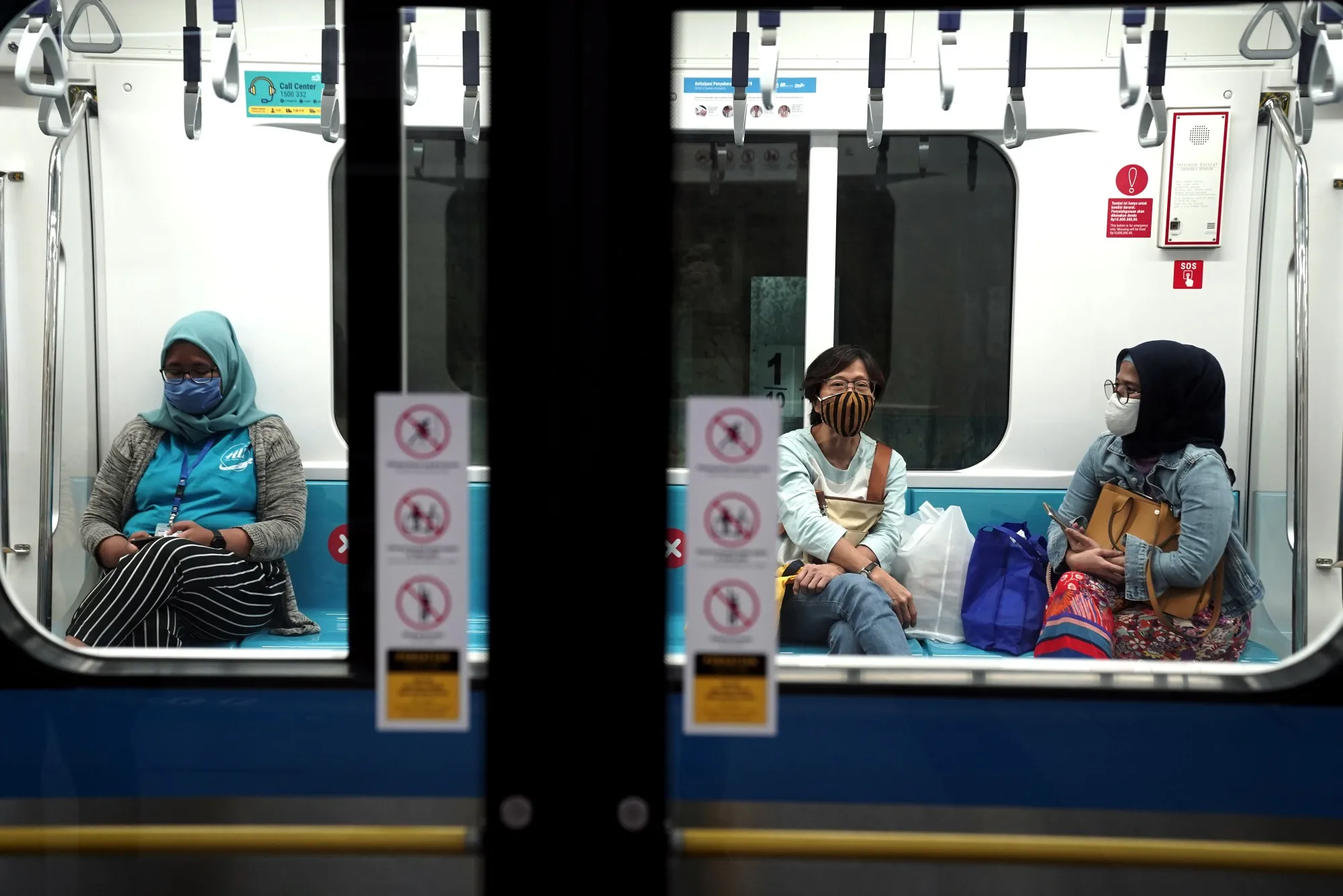 Passengers wearing protective face masks inside an MRT train in Jakarta, July 8.