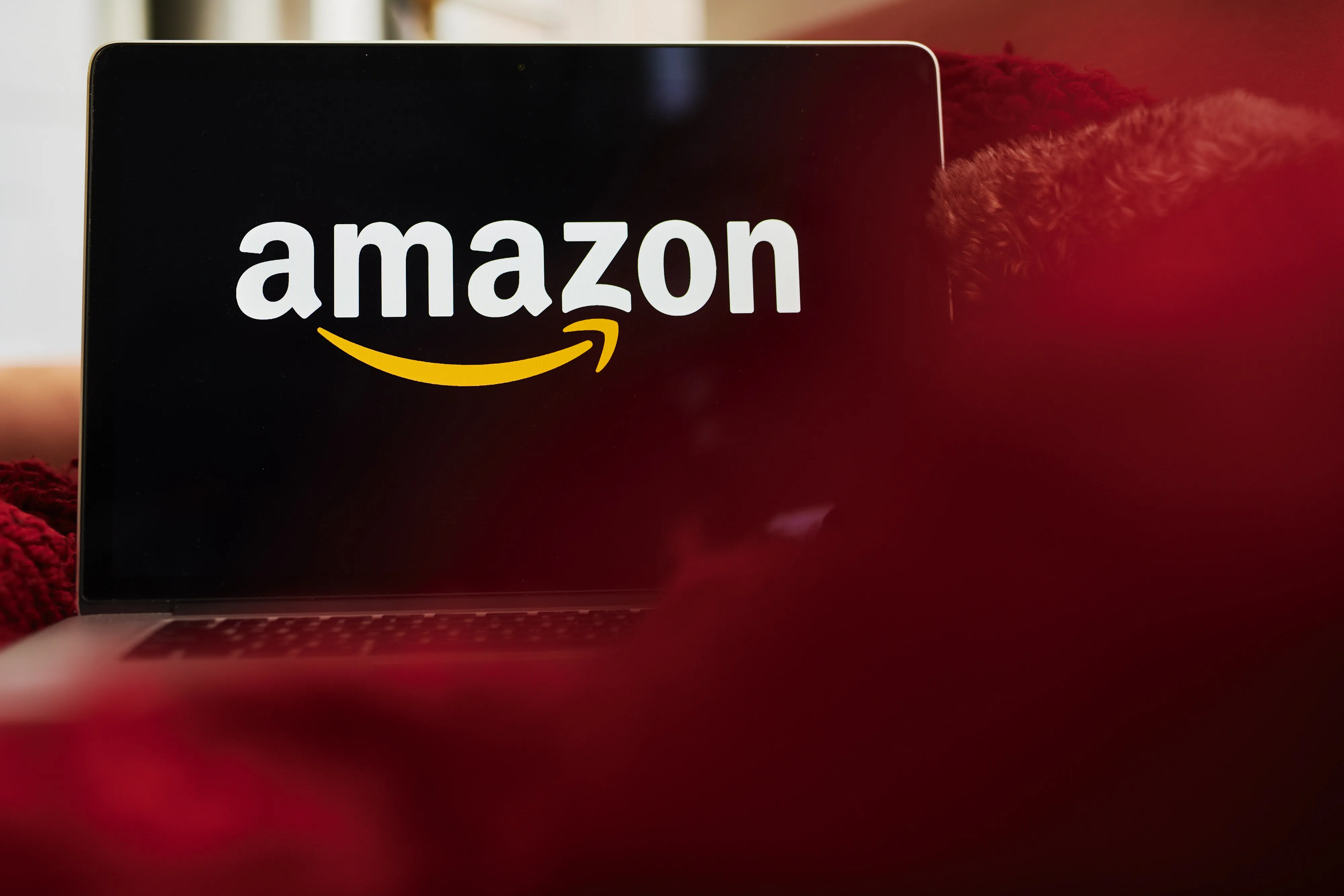 The logo for Amazon.com is displayed on a laptop computer.