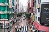 Pedestrians holding umbrellas walk past stores as rain falls in the Shinjuku district of Tokyo, Japan, on Sunday, June 14, 2020. Tokyo lifted the city’s virus alert and moved into the next and final phase of its reopening as the Japanese capital continued its recovery.