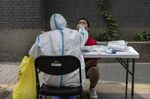 A healthcare worker collects a swab sample from a resident at a Covid-19 testing facility in Beijing.