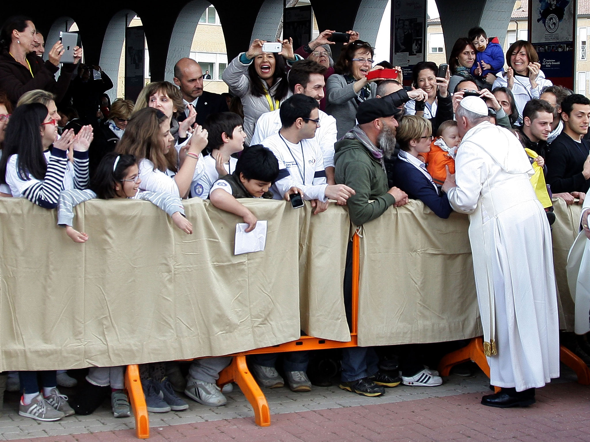Pope Francis greets the faithful as he arrives at the Don Gnocchi Centre for the elderly and disabled for the Maundy Thursday Mass on April 17, 2014 in Rome.
