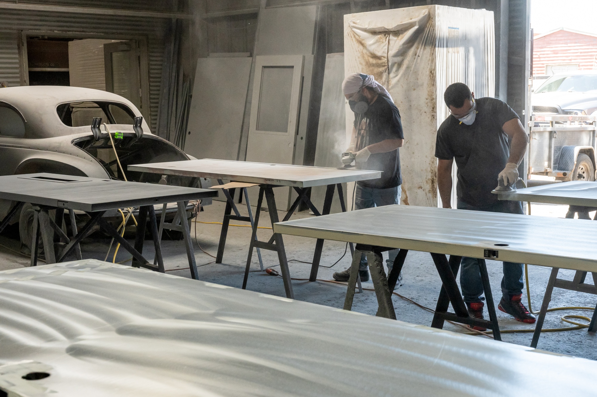 Workers sand metal doors at a metal manufacturing facility in Sacramento, California.